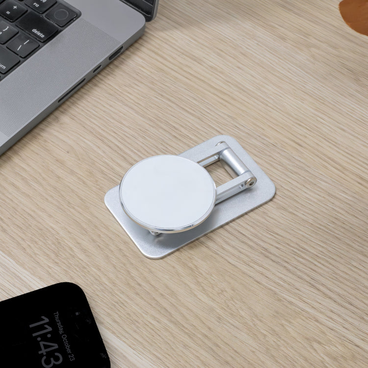 Phone holder on a wooden desk with a laptop and smartphone in the background