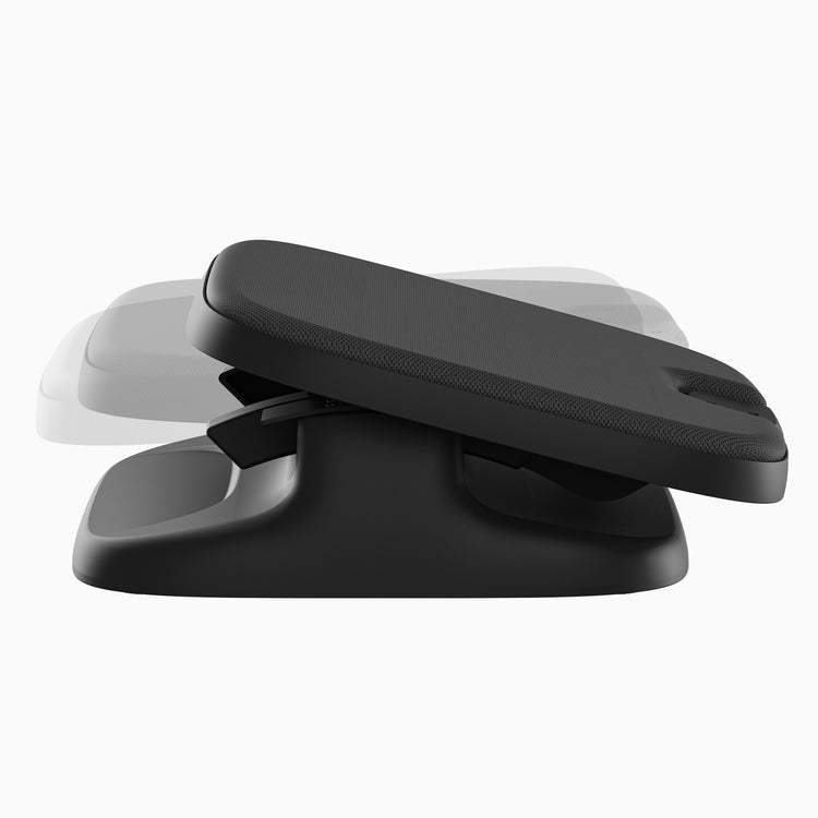 A black ergonomic desk footrest with a textured top surface, shown at an angle