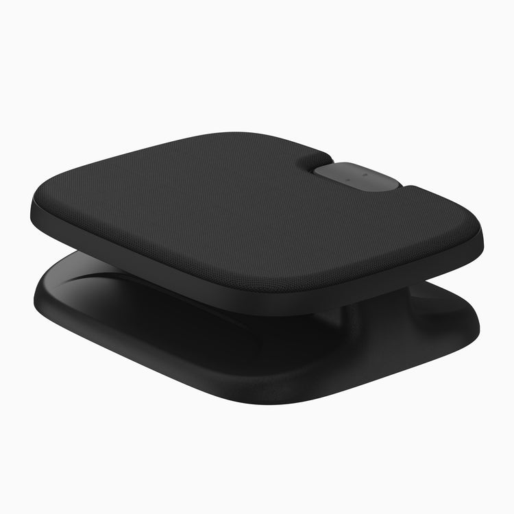A black ergonomic foot rest with textured top surface and a smooth base, shown on a plain white background.