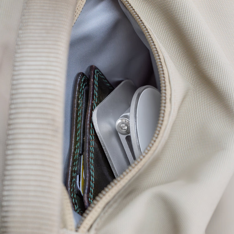 Close-up of a beige bag with a wallet and phone inside