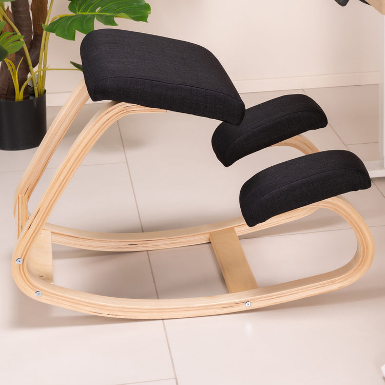 Ergonomic black kneeling chair on floor