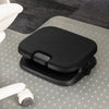 A black ergonomic footrest with a textured fabric top and adjustable base
